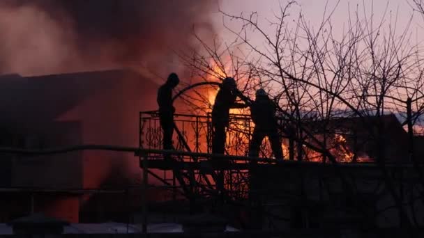 Kiev, Ukraine - March 27, 2021: Firefighters extinguish a private house. The cottage is on fire, the flames are spreading through the house. — Stock Video