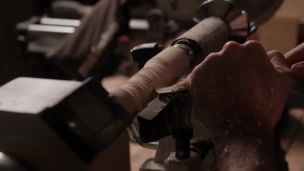 Bir marangoz torna tezgahında çalışıyor. Genç bir adam makineye ağaç dikiyor.. — Stok video