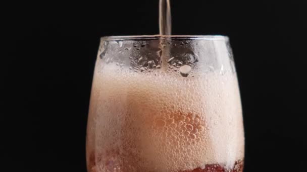 Frisdrank frisdrank in een glas met ijsblokjes close-up op een zwarte achtergrond. — Stockvideo