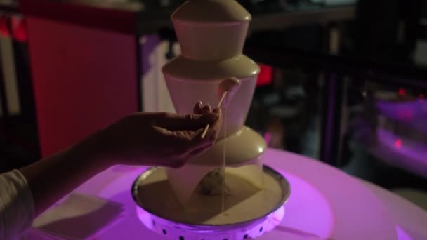 Chocolate fountain with white chocolate in a nightclub close-up. — Stock Video