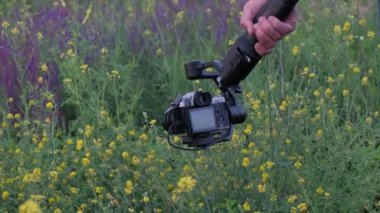 Kiev, Ukrayna - 27 Haziran 2020: Bir adam elinde bir dengeleyiciyle bir kamera tutuyor ve doğanın fotoğraflarını çekiyor