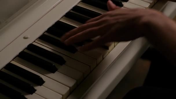 Muž hraje na bílé piano. Mužské ruce zblízka na klavír klávesy. — Stock video