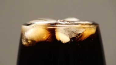 Yakın planda buzlu kola içeceği. Gri arkaplanda makro.