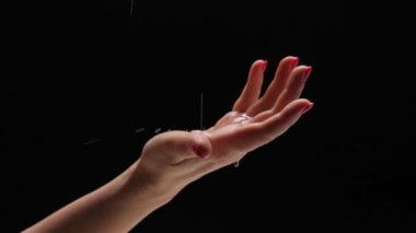 Siyah arka planda aromatik yağı olan bir masörün elleri..