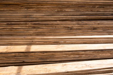 Bir kereste fabrikasındaki tahta yığınları, resmi işler. Açık hava kereste atölyesinde testere kullanmak için depo. Kalas dokusu.