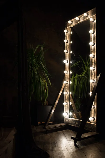 Miroir de toilette se tient sur un sol en bois avec des ampoules pour l'éclairage — Photo