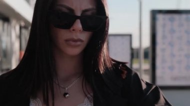 Siyah takım elbiseli bir iş adamı kız saatine bakar ve geç kalır. Yaz güneşli bir gün.