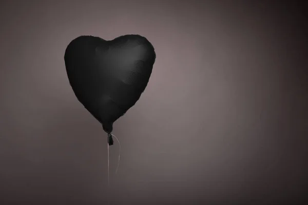 Bola negra en forma de corazón sobre fondo gris en el estudio — Foto de Stock