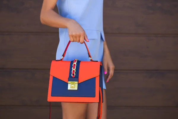 Stylish blue with orange leather women bag. The girl holds in her hand. Bag close up. — Stock Photo, Image