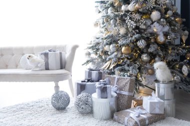 Karla kaplı bir Noel ağacı, gümüş sarısı süsler ve hoş, rahat bir atmosfer yaratan hediyeler..