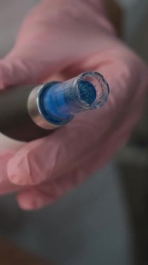 Bir güzellik kliniğinde gelişmiş cilt bakımı ve estetik tedavide kullanılan pembe tıbbi eldivenlerde tutulan profesyonel mikro donanım..