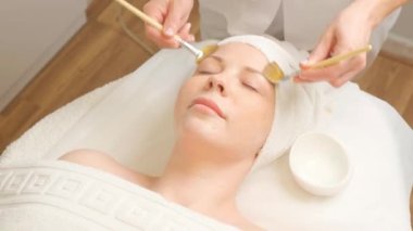 Rahatlatıcı güzellik tedavisi sırasında kozmetik maskeli bir uygulama alan kadın