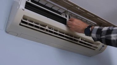 Duvar havalandırma filtresi, ekoseli gömlekli eller tavandan kirli ağ filtresi çıkartılan bölme ünitesi tıkanmış toz ve kiri ortaya çıkarıyor.