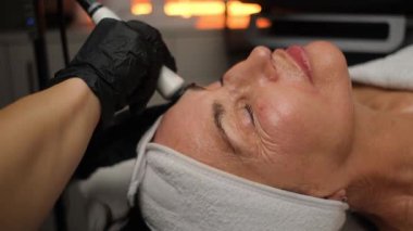 Olgun bir kadın için gelişmiş radyoaktif cilt gerdirme seansı. Kozmetik salonlarında yaşlanma karşıtı modern cilt bakımı..