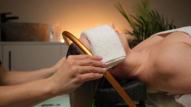 Sakinleştirici kafa derisi ve su akışıyla yapılan saç bakımında bir kadının yer aldığı lüks sağlık deneyimi.