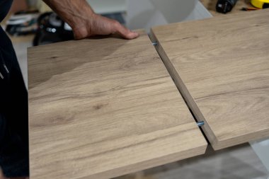 Ceviz tahtası tezgahta kesiliyor, paneller, klemp ve yönlendirme araçları arasında plastik boşluk ile el rehberi, ince