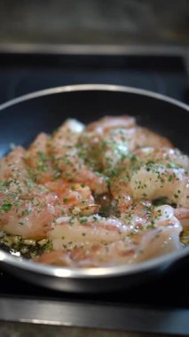 Zeytinyağlı karides sotesi, sarımsak ve maydanozla birlikte fırının üstünde taze, ev yapımı deniz ürünleri yemeği hazırlıyor.