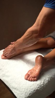 Erkek terapist kadın bir müşteriye ayak masajı yapıyor. Sağlık ve sağlık için akupres noktaları üzerinde çalışan profesyonel masör.