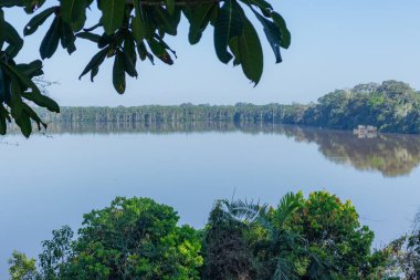 Mavi gölün durgun suları, huzurlu bir doğal ortamda gökyüzünü yansıtıyor. Huzur uyandıran sakin bir manzara ilham ve denge editoryal ya da seyahat tasarımı için mükemmel.
