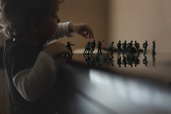 Niño jugando con soldados de juguete — Foto de Stock