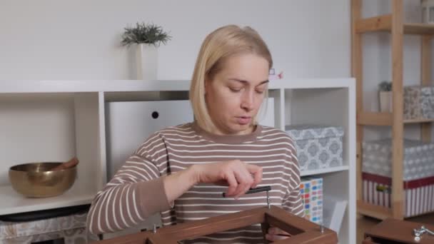 A woman makes repairs with her own hands at home, collecting furniture for self-Assembly. — Stock Footage A woman makes repairs with her own hands at home, collecting furniture for self-Assembly. Royalty Free Stock Video