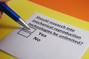 Bir kişi mekanik üreme teknolojileri araştırmalarıyla ilgili soruları cevaplıyor..