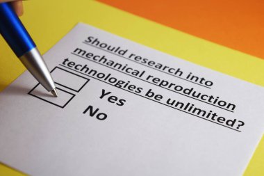 Bir kişi mekanik üreme teknolojileri araştırmalarıyla ilgili soruları cevaplıyor..