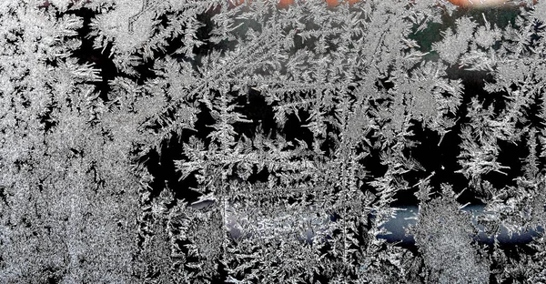 Frosty natural pattern on a winter window, texture of frosty patterns, dendritic image structure