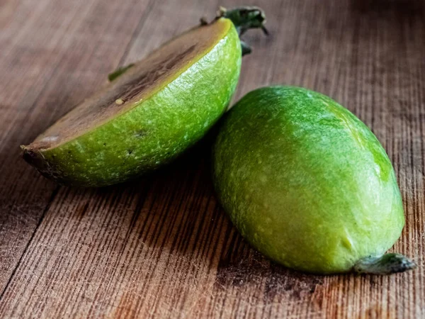 Färsk mogen feijoa frukt på en träskiva skuren på mitten — Stockfoto