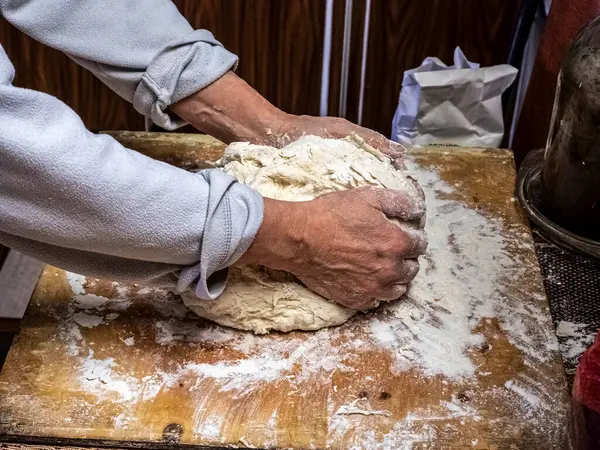 Fabrication de la pâte à la main avec une vue d'une personne mains pétrissant la pâte — Photo