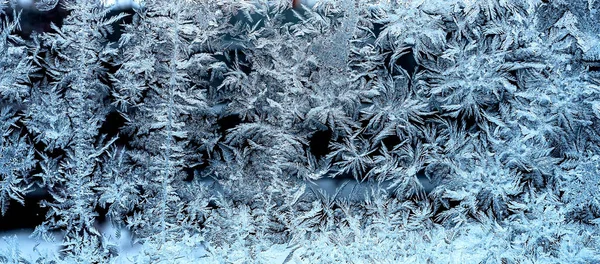 Frosty natural pattern on a winter window, texture of frosty patterns, dendritic image structure