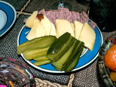 Tabakta sosis, peynir ve turşu dilimleri olan basit Rus mezeleri.