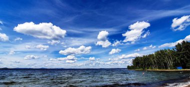 Sabah gölünde beyaz kümülüs bulutları ile panorama mavi gökyüzü, Güney Urallar, Uvildy Gölü