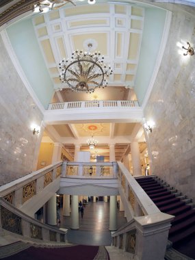 Opera ve bale salonunda kırmızı halılı merdivenler, mermer korkuluklar ve duvarlar, kristal avizeler ve lambalar, Doric başkentlerinin olduğu sütunlar, Rusya, fishay lensleri