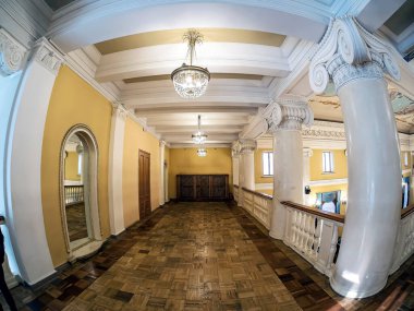 Opera ve bale salonunun balkonundaki sütunlar, sütunların başkentleri iyonik tarzda dekore edilmiştir, klasik tiyatro kristal avizeleri, boyanmış tavan, Rusya, balık gözü lensleri.