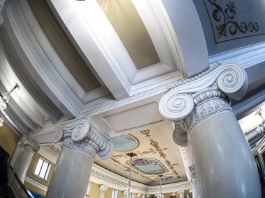 Opera ve bale salonunun balkonundaki sütunlar, sütunların başkentleri iyonik tarzda dekore edilmiştir, klasik tiyatro kristal avizeleri, boyanmış tavan, Rusya, balık gözü lensleri.