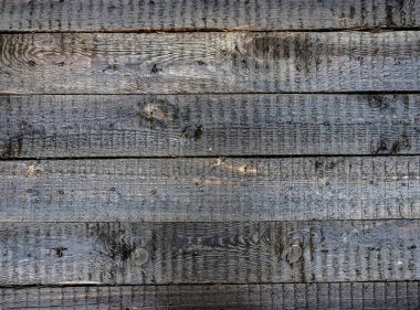 Yağmurdan sonra gölün kıyısındaki ıslak tahtalardan yapılmış bir kalkanın parlak dokusu