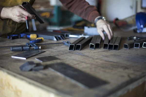 Schweißer wählt Werkzeuge und vorgeschnittene Stahlteile. — Stockfoto