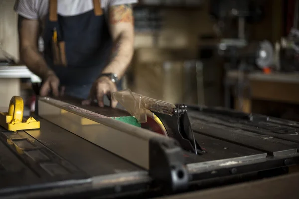 Custom furniture craftsman cuts wood with saw. Stock Photo