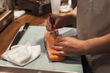 Bir suşi şefi balık gece servisi için hazırlar.. 