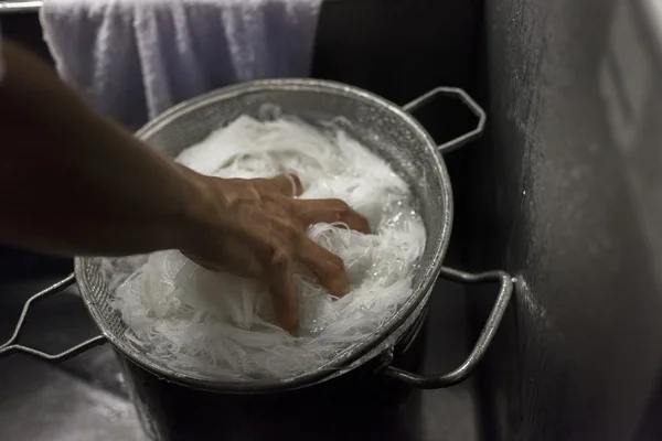 Un chef refroidit les nouilles chaudes dans un bain de glace . — Photo