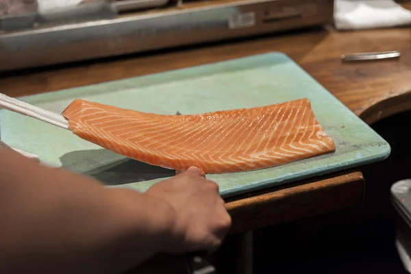Een sushi chef-kok bereidt vis voor Nachtschakeling. — Stockfoto