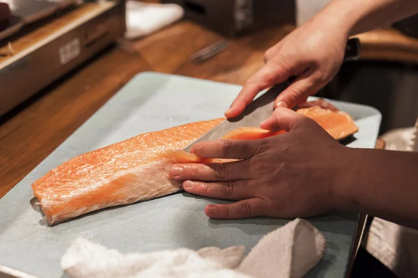 Un chef sushi prépare du poisson pour le service de nuit . Image En Vente