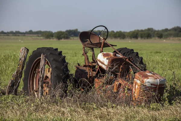 Opuštěné rezavé traktorových v poli. Stock Fotografie
