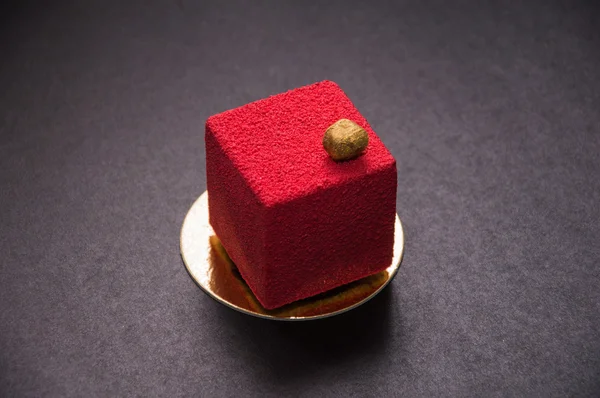 Red dessert with nuts on top