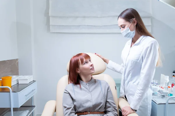 Beautician consults a woman in a beauty salon. The patient sits in a cosmetic chair and smiles at the specialist. Mixed media