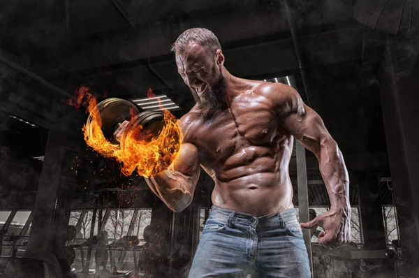 Professional athlete trains with a fire dumbbell in the gym. Bicep pumping. Bodybuilding and fitness concept. Mixed media