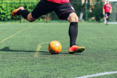 Futsal / futbol / futbol. Bir oyuncu suni çim topa vurur