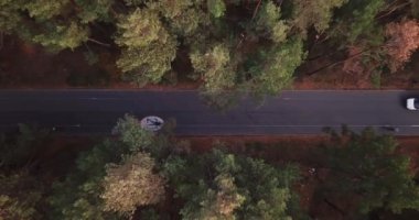 İnsansız hava aracı 20 km 'lik hız sınırı olan bir bisiklet yolu ile orman yoluna çıkıyor. Beyaz minibüs bisikletçileri.