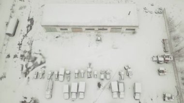 İnsansız hava aracından, terk edilmiş, karla kaplı bir araç filosuna bakın.